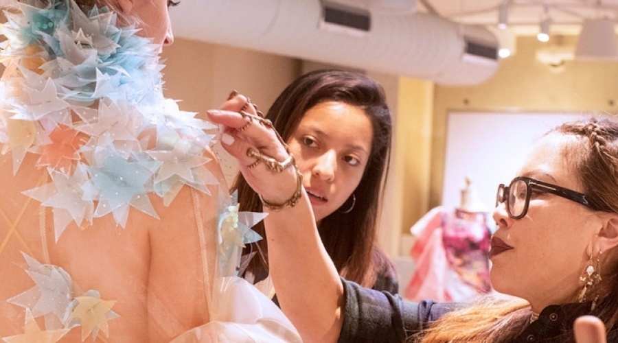 Chris Chang, 2017-18 Fashion Mentor looking over a student design