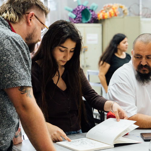 Student showing their portfolio to a professor